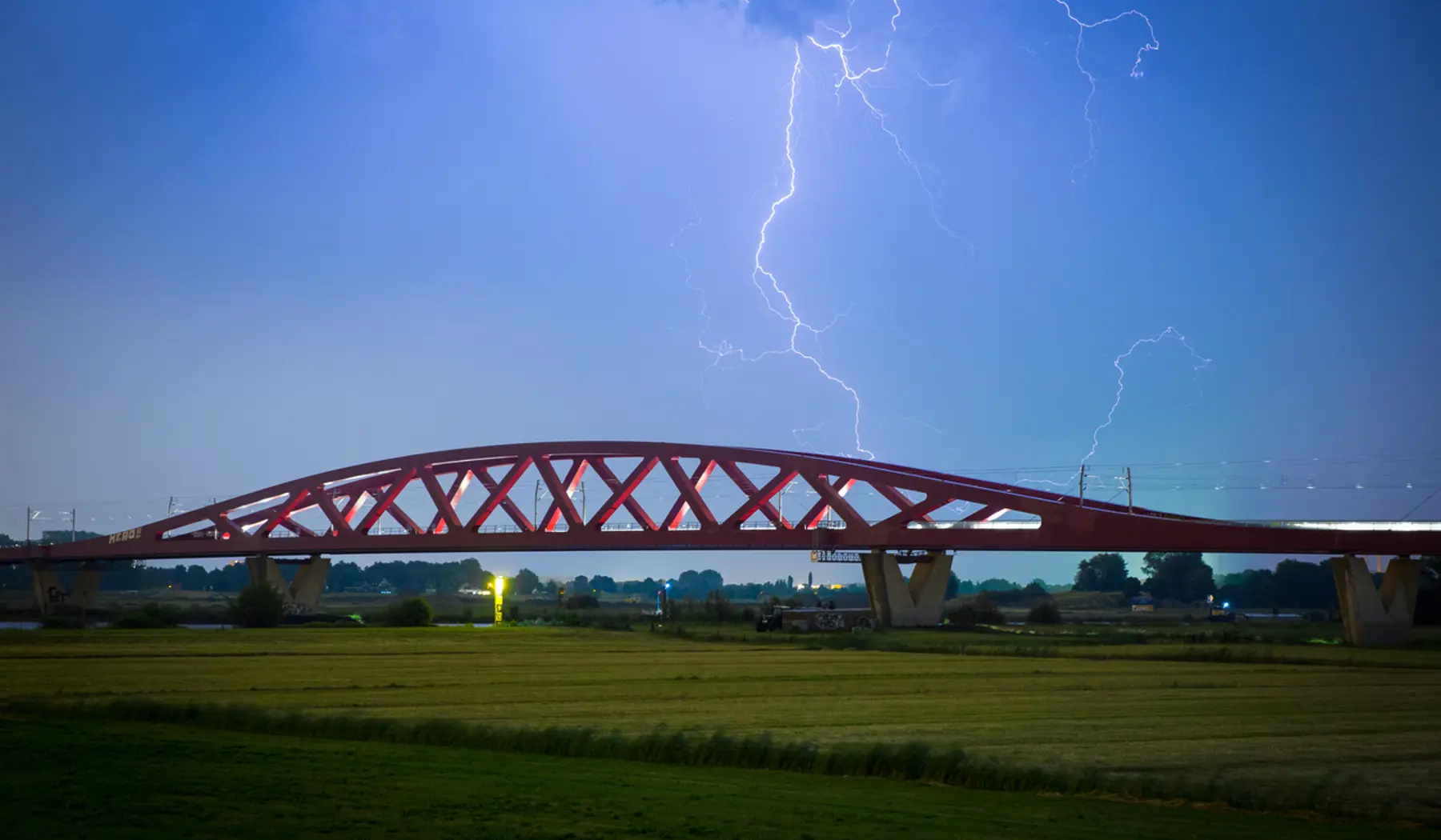 Bliksem boven een spoorbrug