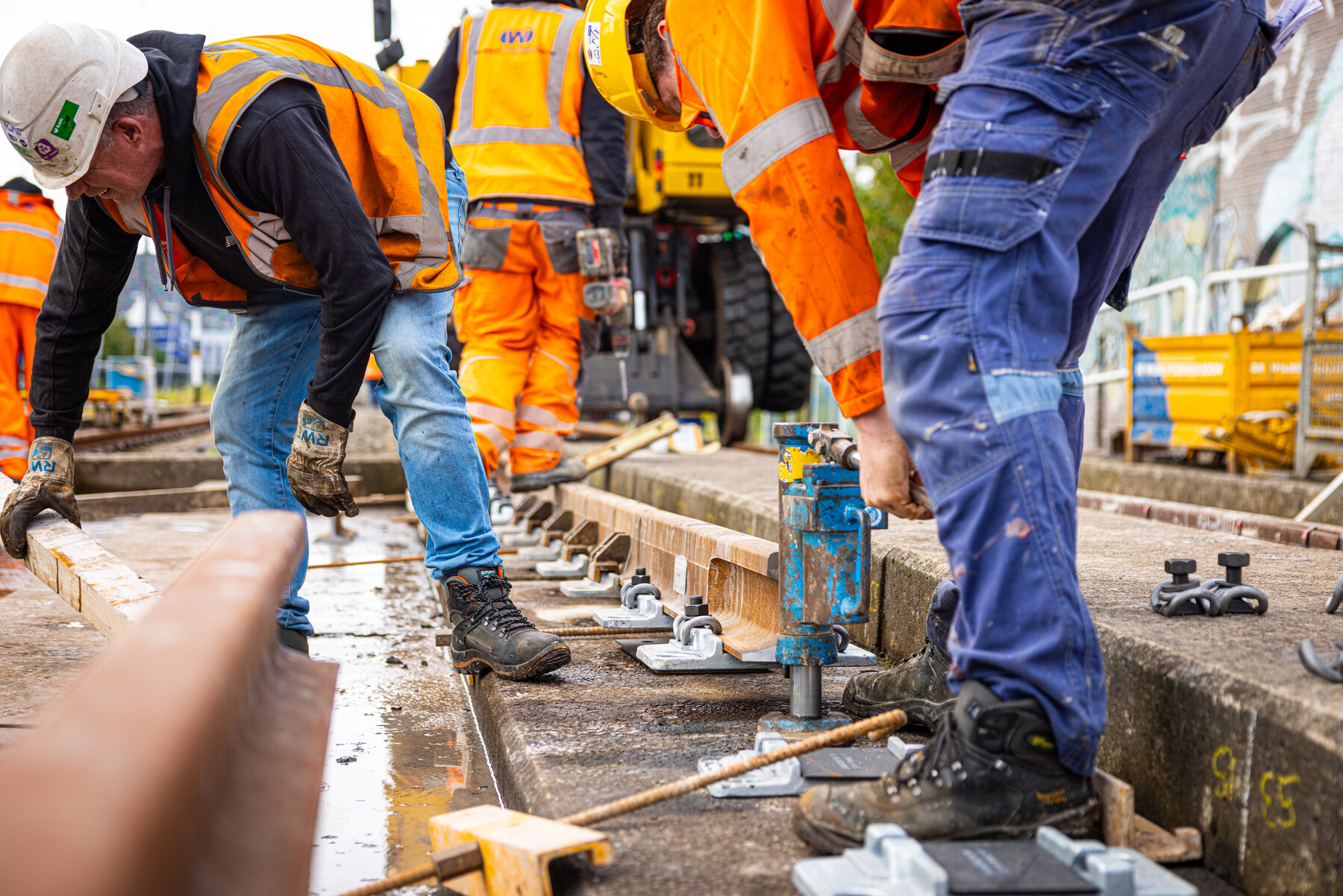 De rails wordt met speciale klemmen op de spoorbrug gemonteerd